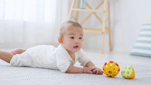 Bayi sedang melakukan tummy time.