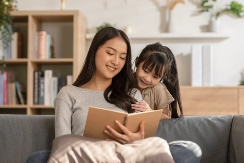 Ibu dan anak sedang membaca cerita bergambar.