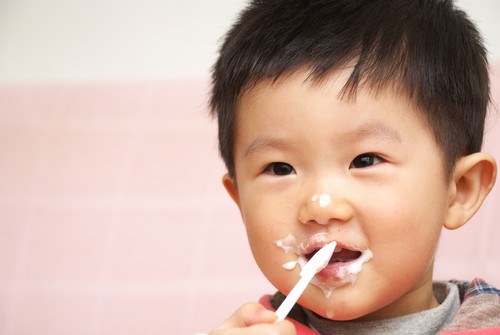 Bayi laki-laki sedang makan yogurt